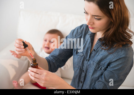 Mother crying baby medicine Banque D'Images