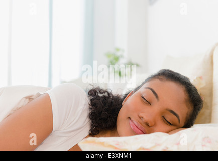 Mixed Race woman sleeping in bed Banque D'Images