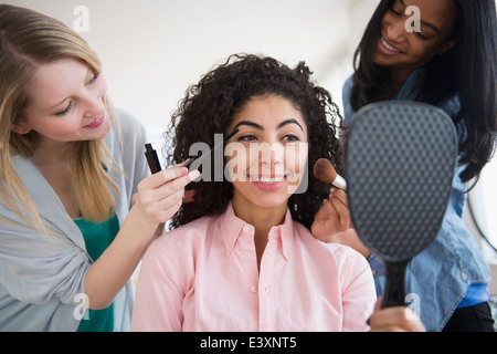 Les femmes qui font l'ami makeup in mirror Banque D'Images