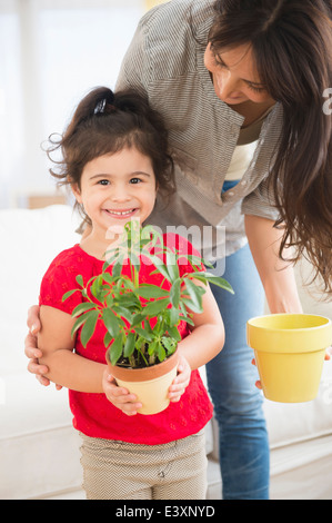 Hispanic mother and daughter gardening together Banque D'Images