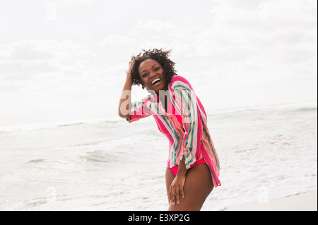 African American Woman laughing on beach Banque D'Images