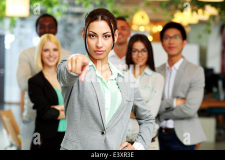 Businesswoman pointing at camera devant des collègues Banque D'Images