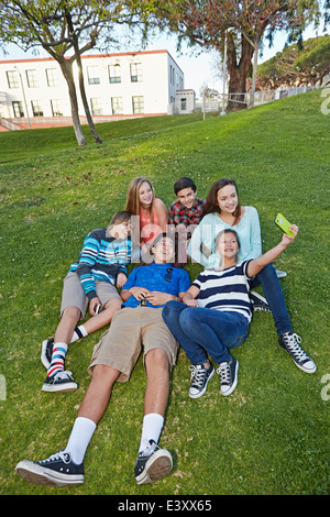 Les adolescents de prendre photo ensemble dans l'herbe Banque D'Images