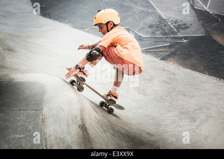 Mixed Race boy riding skateboard dans skate park Banque D'Images