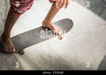 Mixed Race boy riding skateboard dans skate park Banque D'Images