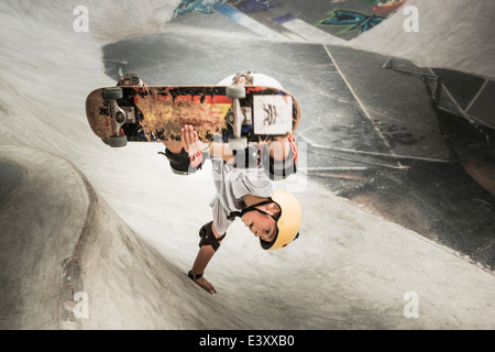 Mixed Race boy riding skateboard dans skate park Banque D'Images