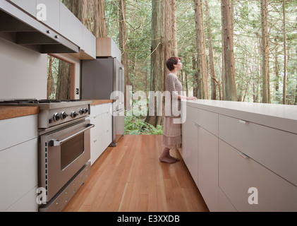 Femme debout dans la cuisine en forêt Banque D'Images