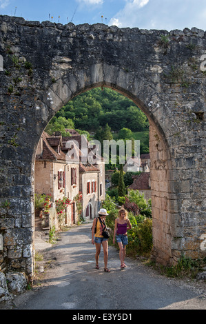 Les touristes marchant à travers la ville au village médiéval de Saint-Cirq-Lapopie, Lot, Quercy, Midi-Pyrénées, France Banque D'Images