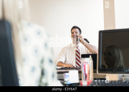 Avocat d'affaires chatting on smartphone in office Banque D'Images