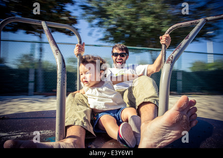 Père et fille tout-petit rond-point tourner sur park Banque D'Images