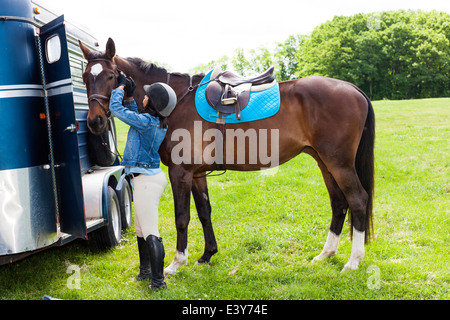 Horse Rider mise sur horse's bridle Banque D'Images