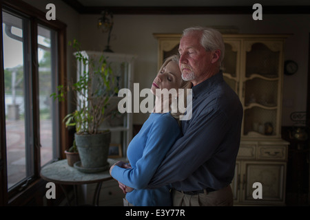 Mature couple hugging romantique avec les yeux fermé en salle à manger Banque D'Images