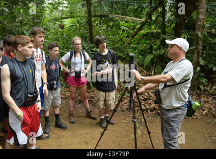 Groupe d'écotouristes adolescentes sur une écologie de la forêt tropicale à pied, Selva Verde, Costa Rica. Leur guide est un naturaliste du Costa Rica Banque D'Images