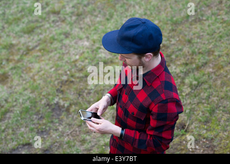 Portrait of mid adult man texting on smartphone Banque D'Images