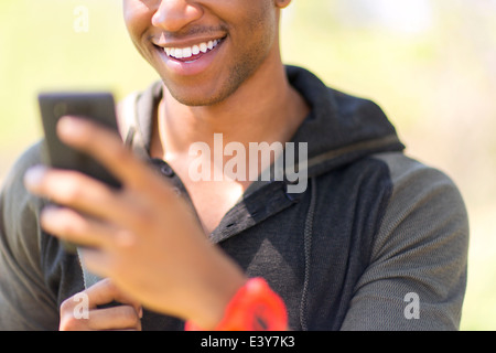 Close up of young male hiker looking at smartphone Banque D'Images