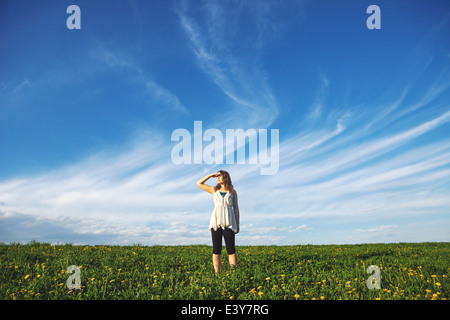 Young woman standing in field Banque D'Images