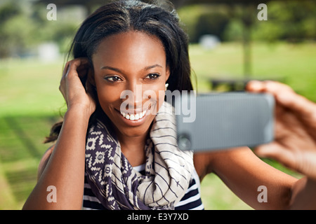 Young woman taking self portrait sur smartphone Banque D'Images