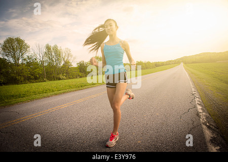 Teenage girl running on road Banque D'Images