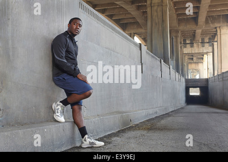 Young male runner en faisant une pause sur le pont de la ville Banque D'Images