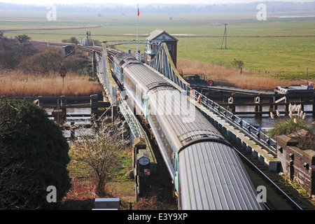 Un train de voyageurs transportés diesel traversant la rivière Yare sur pont tournant Reedham, Norfolk, Angleterre, Royaume-Uni. Banque D'Images