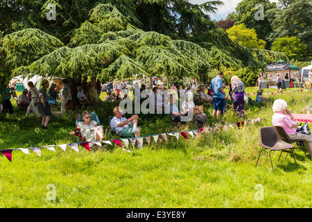 L'est du Devon, Angleterre. Une fete et garden party avec des gens assis à l'ombre des arbres et, en général, se détendre au soleil. Banque D'Images