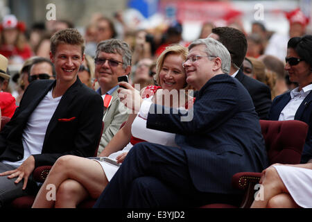 Ottawa, Canada. 1er juillet 2014. Le premier ministre du Canada, Stephen Harper (R) et épouse Laureen (C) tenter de prendre un tout en selfies leur fils Benjamin ressemble au cours de cérémonies pour célébrer le 147e du Canada, sur la Colline du Parlement à Ottawa, Canada, le 1 juillet 2014. Crédit : David Kawai/Xinhua/Alamy Live News Banque D'Images