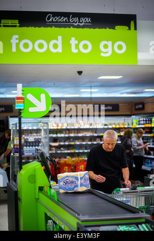 L'homme en utilisant un libre-service jusqu'à un supermarché Asda en 2014 Banque D'Images