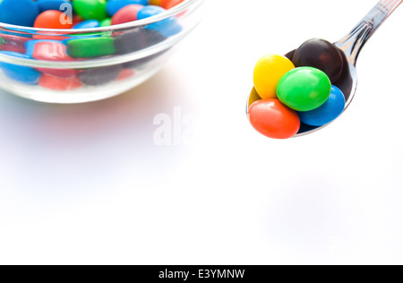 Boutons de chocolat colorés cuillère et bol Banque D'Images