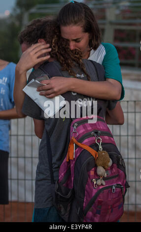 Modi'in. 1er juillet 2014. Les jeunes femmes israéliennes s'embrassent à une réunion commune de funérailles pour les trois adolescents israéliens à un cimetière à Modi'in, près de Jérusalem, le 1 juillet 2014. Les trois adolescents israéliens dont les corps ont été retrouvés lundi soir ont été portées à reste côte à côte le mardi à l'occasion d'une tenue funèbre à Modi'in près de Jérusalem. Des dizaines de milliers de personnes ont participé à l'enterrement, y compris le Premier Ministre Benjamin Netanyahu et le Président Shimon Peres, qui éloge des trois, dont les cercueils ont été emballés avec des drapeaux israéliens. Crédit : Li Rui/Xinhua/Alamy Live News Banque D'Images