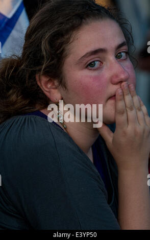 Modi'in. 1er juillet 2014. Une jeune femme israélienne pleure pour les trois adolescents israéliens lors d'un salon funéraire conjointe à un cimetière à Modi'in, près de Jérusalem, le 1 juillet 2014. Les trois adolescents israéliens dont les corps ont été retrouvés lundi soir ont été portées à reste côte à côte le mardi à l'occasion d'une tenue funèbre à Modi'in près de Jérusalem. Des dizaines de milliers de personnes ont participé à l'enterrement, y compris le Premier Ministre Benjamin Netanyahu et le Président Shimon Peres, qui éloge des trois, dont les cercueils ont été emballés avec des drapeaux israéliens. Crédit : Li Rui/Xinhua/Alamy Live News Banque D'Images