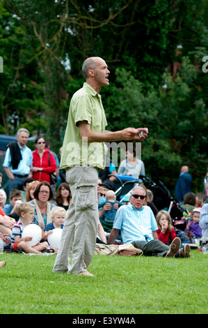 Un homme menant une chorale communautaire à Leamington Festival de la paix, UK Banque D'Images