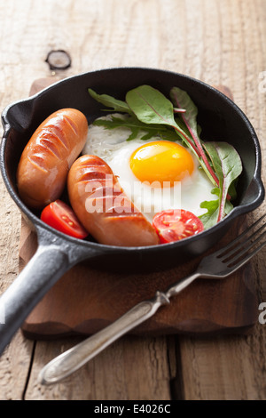 Œuf frit tomates saucisses dans le moule pour le petit déjeuner Banque D'Images