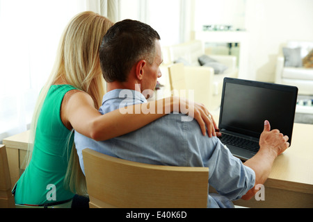 Vue arrière portrait d'un jeune couple using laptop Banque D'Images