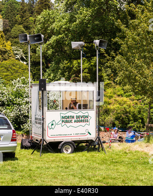 L'est du Devon, Angleterre. Une fête et des jardins de la maison de campagne avec le système de sonorisation et représentant sur le micro. Banque D'Images