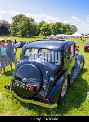 L'est du Devon, Angleterre. Un 1936 Riley Adelphi 12/4 lors d'une fete et garden party inspectée par un couple. Banque D'Images