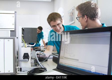 Deux apprentis électroniques communiquant en atelier Banque D'Images