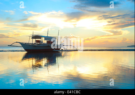 Tropical avec des bateaux traditionnels aux Philippines au coucher du soleil Banque D'Images