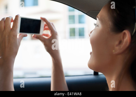 Close up of young woman photographing de taxi Banque D'Images