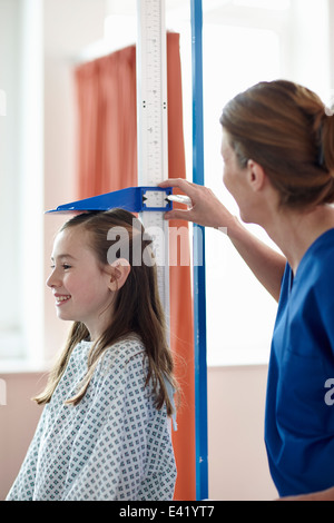 Contrôle de la hauteur de la jeune fille infirmière Banque D'Images