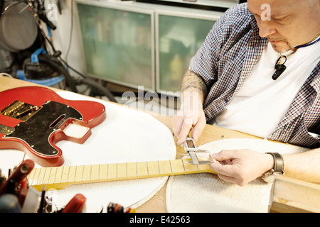 Luthier guitare cou contrôle en atelier Banque D'Images