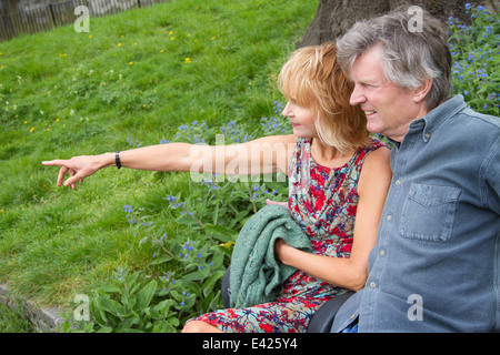 Hot couple sitting on bench in park Banque D'Images