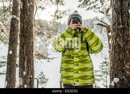 Man taking photograph dans la forêt couverte de neige, la Russie Banque D'Images