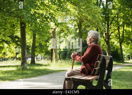 Senior woman sitting on park bench Banque D'Images