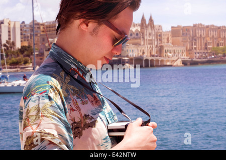 L'homme contrôle son appareil photo, Ta' Xbiex harbour, Gzira, Malte Banque D'Images