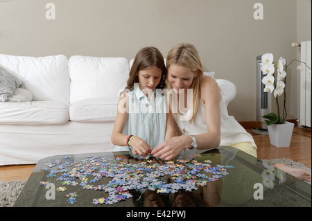 Mère et fille faire puzzle sur table basse Banque D'Images