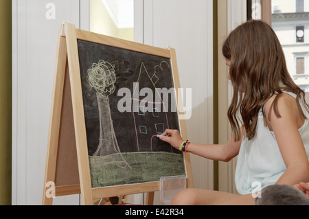 Girl drawing on blackboard Banque D'Images