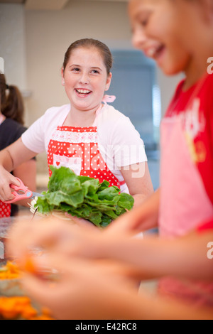 Adolescentes comment préparer les légumes dans la cuisine Banque D'Images