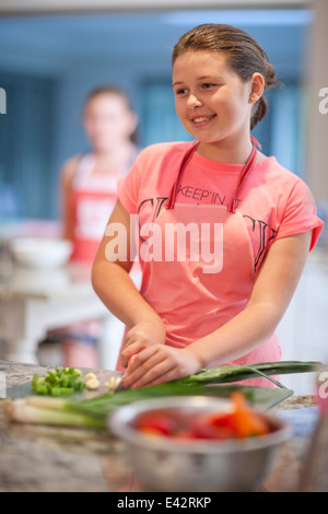 Teenage girl préparer les poireaux dans la cuisine Banque D'Images