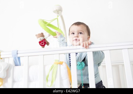 Bébé garçon et contempler l'alerte de crib Banque D'Images