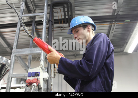 Électricien mâle cable alimentation contrôle en usine Banque D'Images